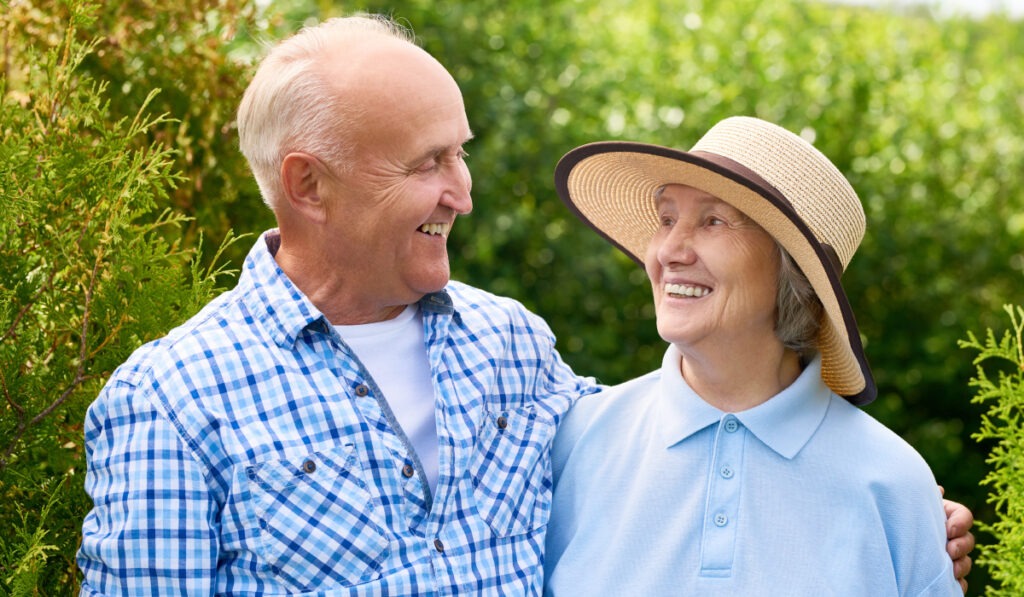 A mature couple out for a walk smiling at each other